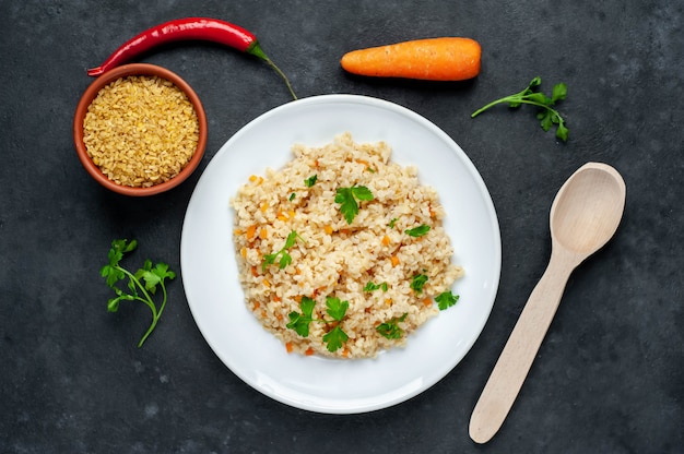 Bulgur with vegetables on a white plate