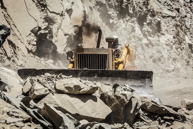 Bulldozer doing mountain road construction in Himalayas Himachal Pradesh India