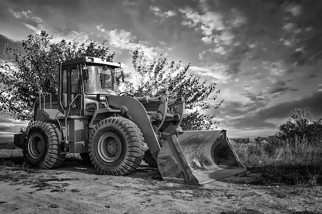 a bulldozer or loader moves the earth at the construction site against the sky