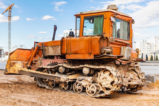 La macchina del bulldozer sta livellando il cantiere. il movimento terra con il bruco sta muovendo la terra. avvicinamento. macchinari pesanti da costruzione.