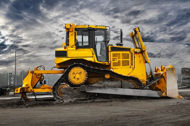 Bulldozer machine is leveling construction site Earthmover with tractor is moving earth Closeup Construction heavy machinery