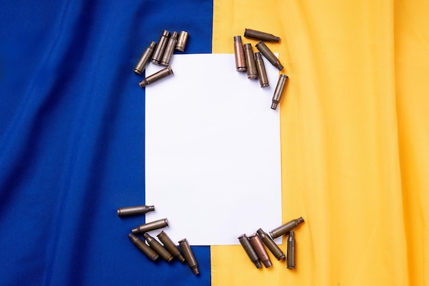 Bullet casings on the flag of ukraine white square for text concept war in Ukraine copy space