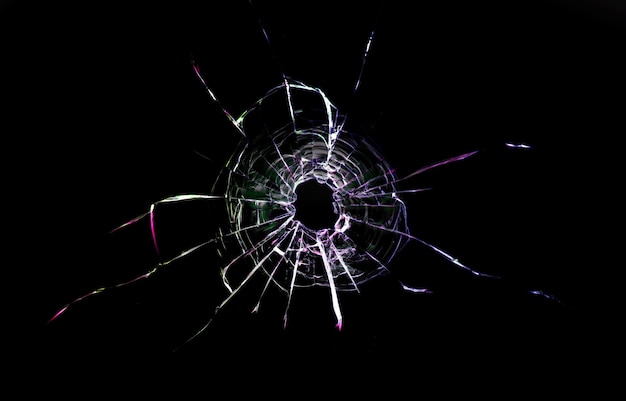 Photo bullet hole in the glass. isolated on a black background.