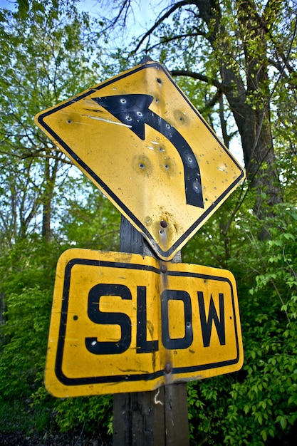 Bullet Holes Slow Down Sign