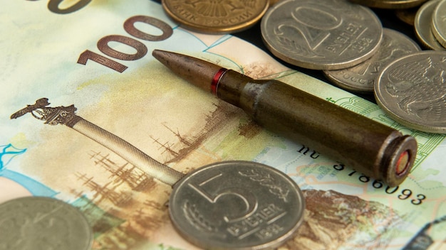 The bullet lies on the Russian banknote among the coins the symbol of Sevastopol the Russian war