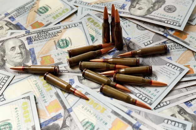 Пули лежат на американских долларовых купюрах торговли оружием