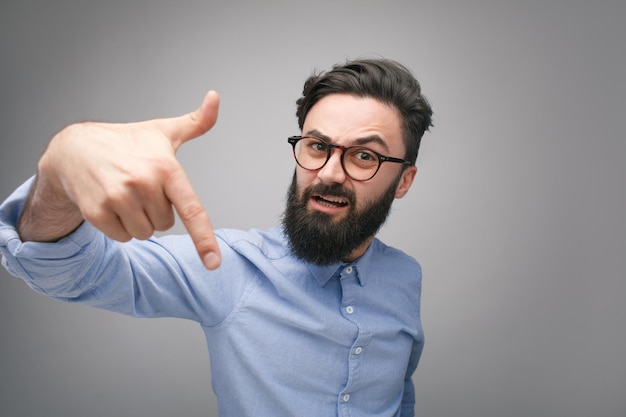 Foto uomo prepotente con gli occhiali che gesturing alla macchina fotografica