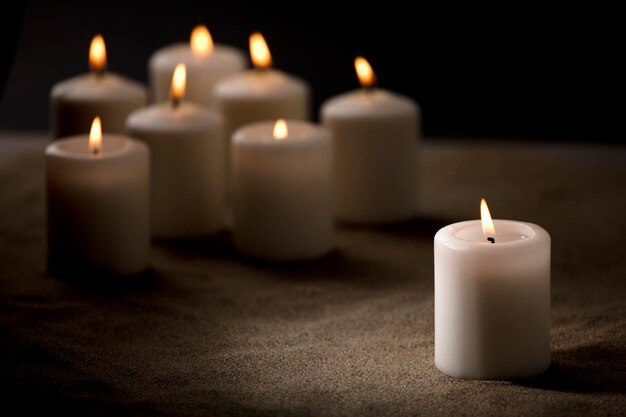 bullying concept composed by group of lit candles on sand with black night background