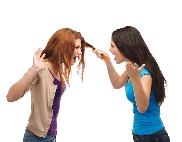 bullying, friendship and people concept - two teenagers having a fight and getting physical