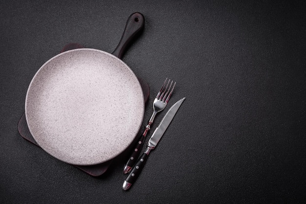 Bumpy empty ceramic plate on a textured concrete background Kitchen utensil item