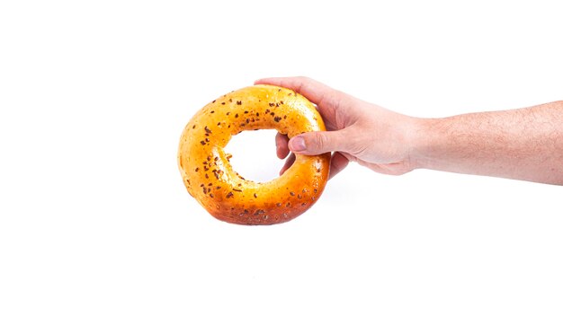 Bun bagel in hand isolated on a white backgroun. High quality photo