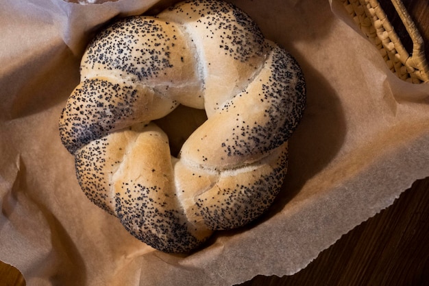 Bun in a basket on parchment. The basket is on a wooden table. Top view