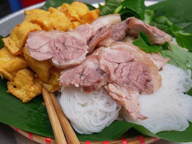 Foto bun cha, tradizionale piatto vietnamita servito a pranzo come cibo di strada ad hanoi. erbe di tagliatelle di riso del tofu fritte carne di maiale tritata sulla foglia e sulla minestra della banana.