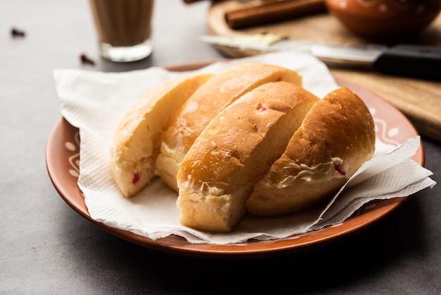 Bun-maska tea o bun maska chai combo presenta un panino leggermente dolce tempestato di uvetta che viene tagliato a metà e carico di burro sano, cibo di mumbai