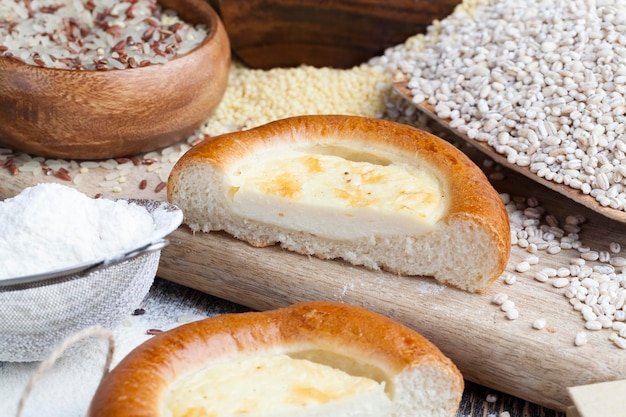 a bun using sour cream on a cutting board with pearl barley grain, food on the table