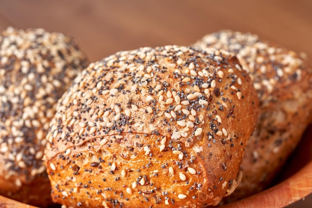 Bun with poppy seeds and sesame on the wooden table.