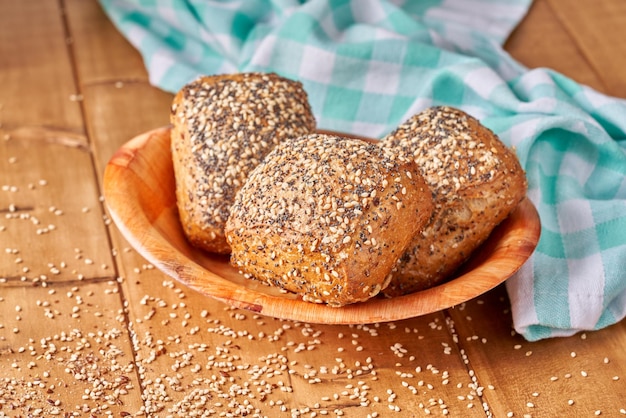 Bun with poppy seeds and sesame on the wooden table.