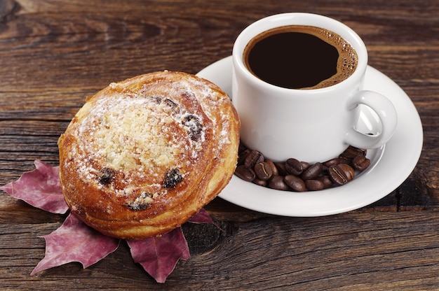 Bun with raisins and cup of coffee