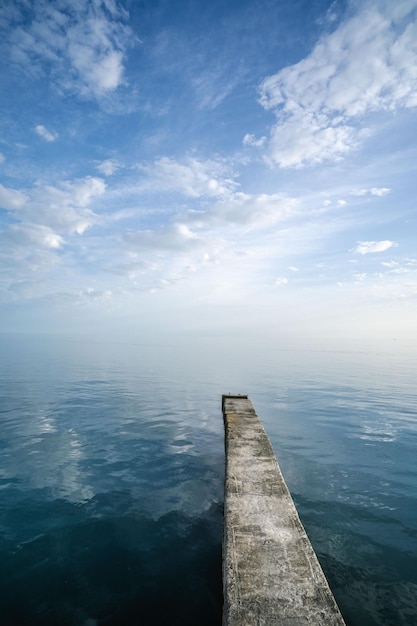 Buna or pier stretching into the distance between the sky and the sea