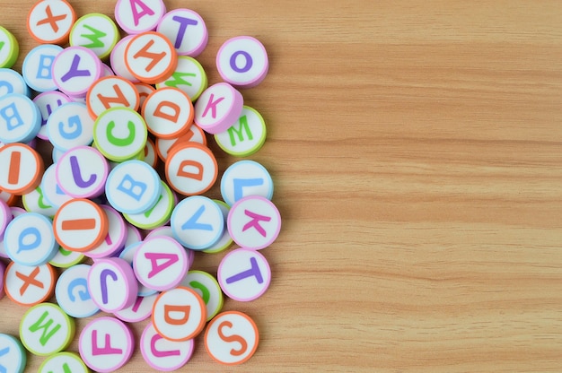 Bunch of alphabet letters on wooden table with copy space