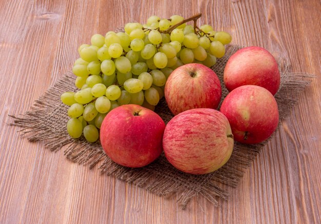 A bunch of apples and a bunch of grapes on a cloth