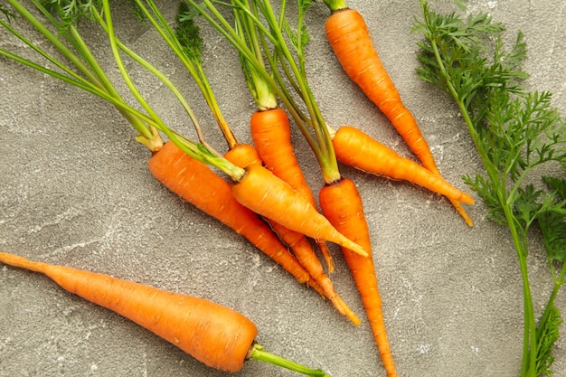 Bunch of baby carrots on grey concrete background Top view