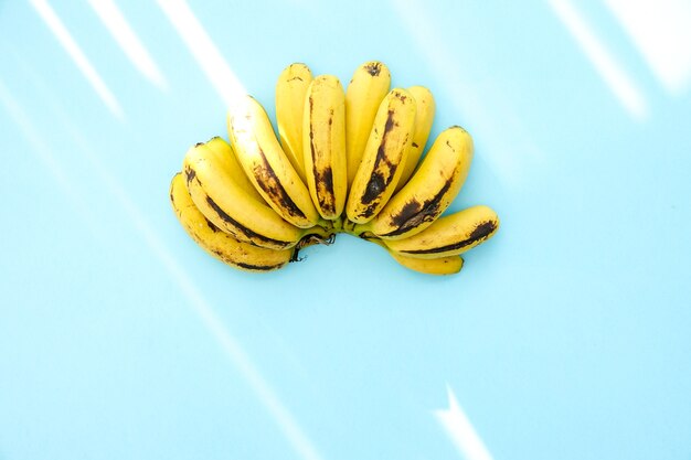 Photo bunch of bananas on blue color background