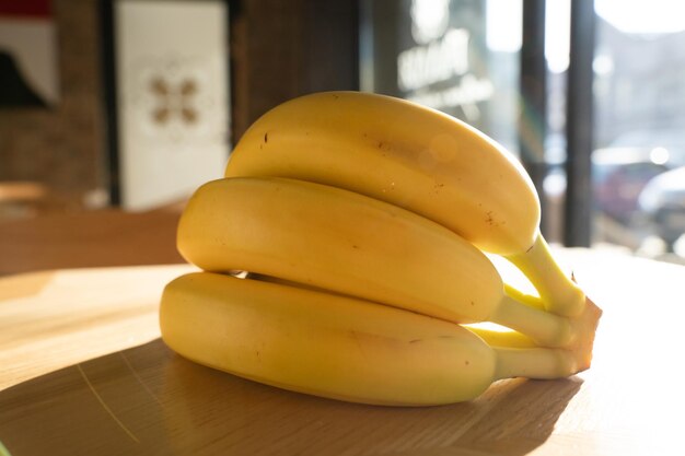 Foto un grappolo di banane disteso sullo sfondo di legno