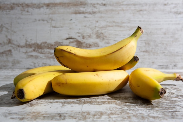 A bunch of bananas placed on the natural medium brown and polished wooden table