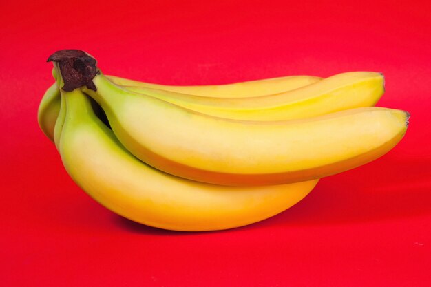 Связка бананов на красном фоне