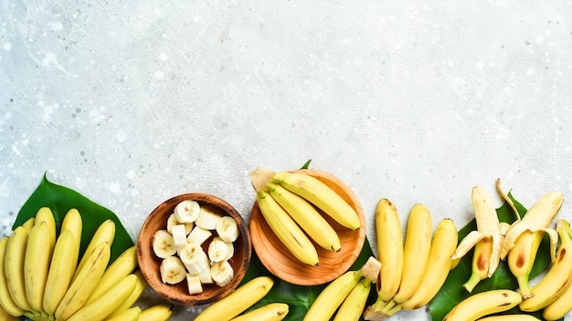 A bunch of bananas and a sliced banana baby on a table delicious natural On a stone background Free copy space Top view