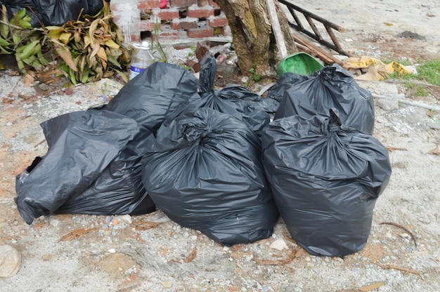 Foto mazzo di sacchi della spazzatura neri sul terreno