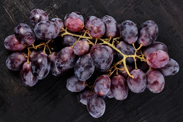 Bunch of black grapes isolated on black background