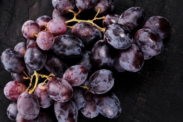 Bunch of black grapes isolated on black background