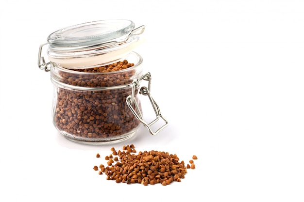 Bunch of buckwheat in jar, close up on a white background. Isolated