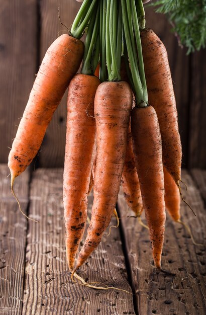 Foto mazzo di carote sulla vecchia tavola. raccolta delle verdure