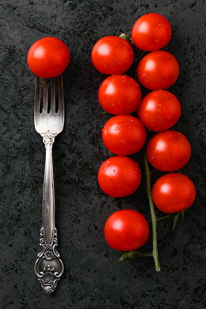 A bunch of cherry tomatoes with tomato on a fork