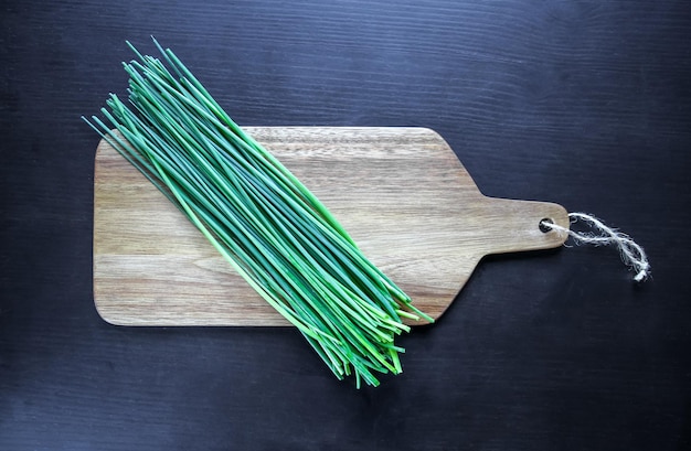 Bunch of chives on a wooden cutting board