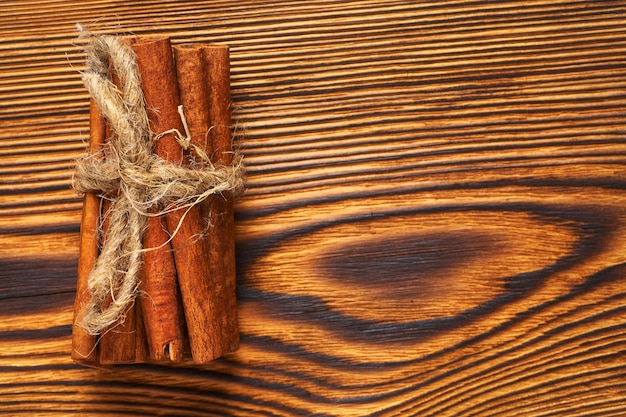 A bunch of cinnamon tied with a rope on wood