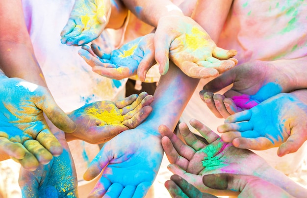 Foto il mazzo di mani variopinte del gruppo degli amici che si diverte alla spiaggia fa festa sulle vacanze estive di festival di colore di holi