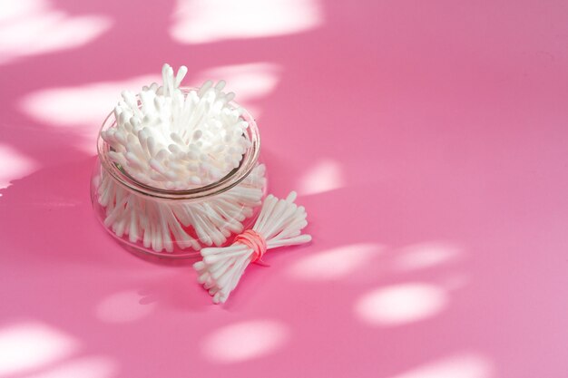 Bunch of cotton buds in a bowl on paper background