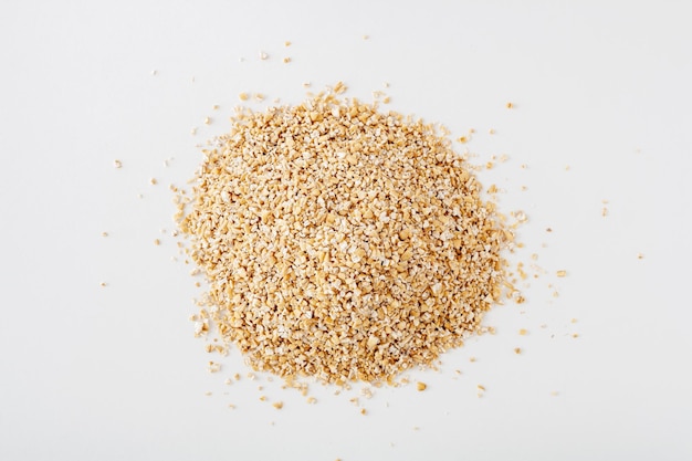 Photo a bunch of crushed oats on a white background copy space