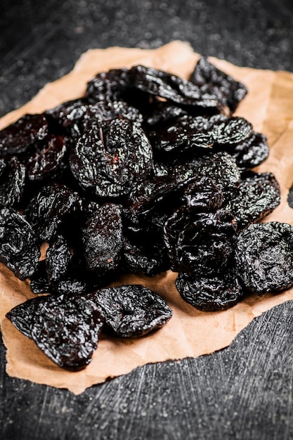 A bunch of delicious prunes on paper on the table