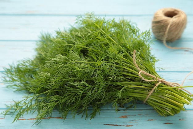 Bunch of dill on blue wooden background with space for text Top view Food for vegetarians