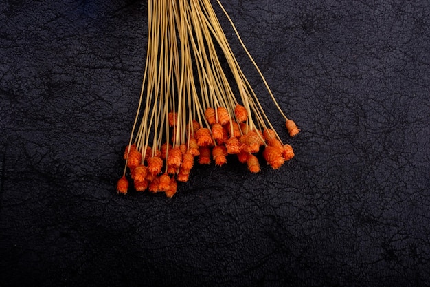 Bunch of dried orange color flower on dark background