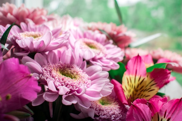 A bunch of flowers are in a vase with a yellow flower