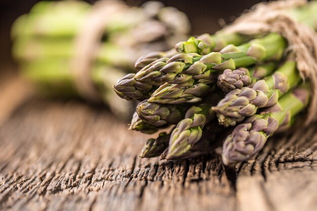 Bunch of fresh asparagus on rustic oak table.