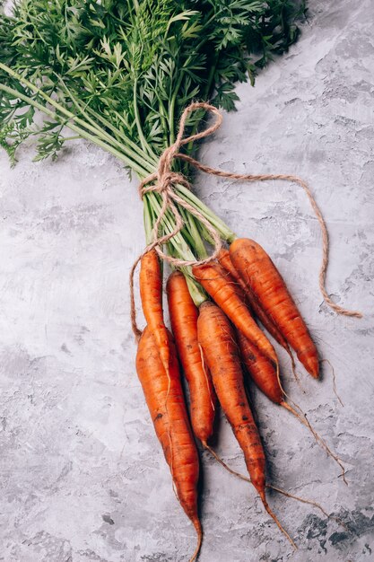 A bunch of fresh carrots on a table with a view from above