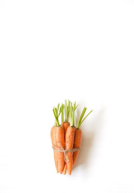 Букет из свежей моркови на белом фоне деревянных