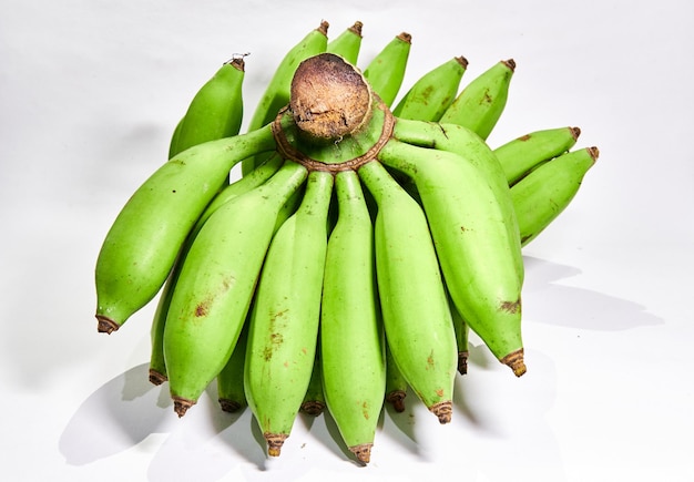 Куча свежих зеленых бананов на белом фоне